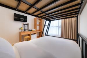 a bedroom with a white bed and a window at Stay5 Jongno in Seoul