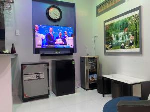 a living room with a tv on a wall at Một Phòng Trong Villa View Sân Vườn, Hồ Bơi in Ấp Phú Khương