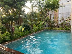 a swimming pool in a garden with trees and plants at Một Phòng Trong Villa View Sân Vườn, Hồ Bơi in Ấp Phú Khương