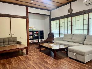 ein Wohnzimmer mit Sofa und Couchtisch in der Unterkunft Goodies Ella Villa & Guesthouse in Shimonoseki