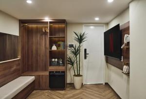 a bathroom with a potted plant next to a door at Centoria Hotel By Urban B in Ho Chi Minh City +49 photos