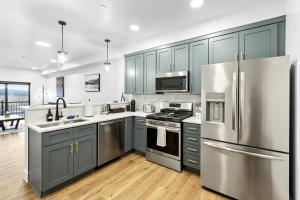 a kitchen with blue cabinets and stainless steel appliances at Airport Access with Stunning View A103 in Juneau