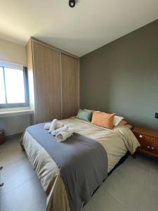 a bedroom with a large bed with towels on it at Terruar Wine in Ciudad Lujan de Cuyo +6 photos
