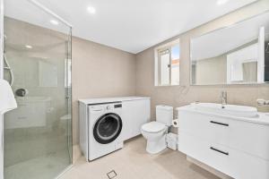 a bathroom with a washing machine and a sink at Paradise Isles in Gold Coast +43 photos