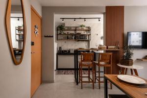 a kitchen with a table and chairs and a counter at Flats Praia Uberlandia - Apt próximo ao Praia Clube - Area de lazer com Portaria 24 horas, piscina, academia, brinquedoteca, churrasqueira e áreas verdes para caminhadas in Uberlândia