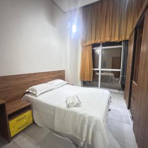 a bedroom with a bed with two slippers on it at Flat Paiva Bugam - Paiva Home Stay in Recife +13 photos