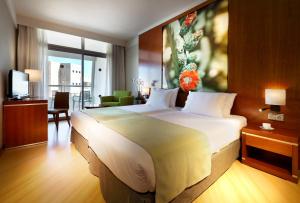 um quarto com uma cama grande num quarto de hotel em Eurostars Las Salinas em Caleta de Fuste