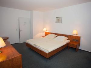 een slaapkamer met een groot bed en 2 lampen bij Hotel Zur Stemmer Post in Minden