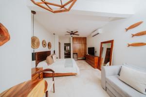a bedroom with a bed and a couch at Villa Marena Hotel Boutique in Coyuca