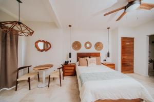 a bedroom with a bed and a desk and a table at Villa Marena Hotel Boutique in Coyuca
