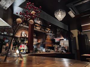 a bar with a vase of flowers on a wooden table at 夕食ご用意可能guesthouse Yokomachi 街の中心部 静かな通りの一棟貸切 in Shingū