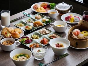 a table with plates of food and bowls of food at AQUASENSE Hotel & Resort in Onna