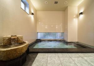 a large indoor pool with a fountain in a building at Super Hotel Sendai Hirose Dori in Sendai