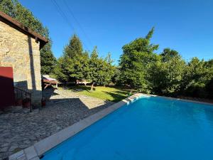 a swimming pool in front of a house at Casa Sequeira de São José - Gerês in Terras de Bouro