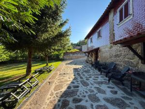 a group of chairs sitting next to a building at Casa Sequeira de São José - Gerês in Terras de Bouro