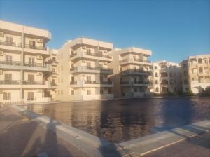 a row of apartment buildings with a body of water at Asala Village, Blue Bay Resort, Marsa Matrouh in Marsa Matruh
