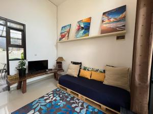 a living room with a couch and a flat screen tv at The Valley Guesthouse in Malang