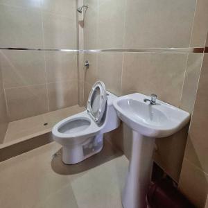 a bathroom with a toilet and a sink at Hotel Delcor Suite in Piura