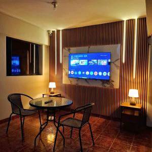 a room with a table and chairs and a tv at Hotel Delcor Suite in Piura