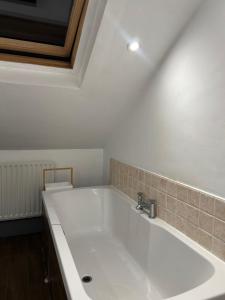 a bathroom with a large white bath tub at Haven Home 3 bedrooms near Sunderland City Centre Downstairs Shower with Toilet and Upstairs Bath with Toilet TV in each room in Sunderland