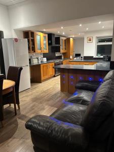 a living room with a couch and a kitchen at Haven Home 3 bedrooms near Sunderland City Centre Downstairs Shower with Toilet and Upstairs Bath with Toilet TV in each room in Sunderland