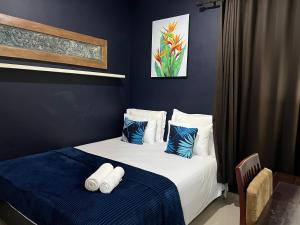 a bedroom with two beds with blue and white pillows at The Valley Guesthouse in Malang +43 photos