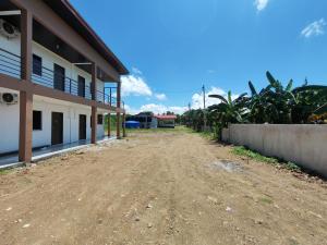 an empty dirt road in front of a building at F&D Homestay in Semporna