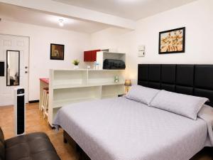 a bedroom with a bed and a desk in it at Casa Postal, Loft cerca del Centro, wifi rápido y estacionamiento in Oaxaca City