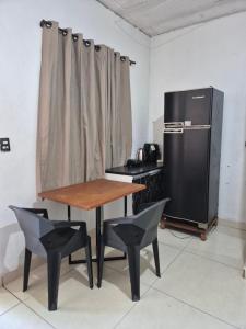 a kitchen with a table and chairs and a refrigerator at Hospedaria Caripí - Suíte 03 in Barcarena