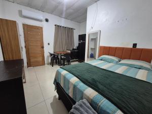 a bedroom with a bed and a desk in it at Hospedaria Caripí - Suíte 03 in Barcarena