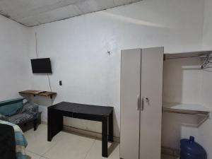 a living room with a desk and a cabinet at Hospedaria Caripí - Suíte 03 in Barcarena