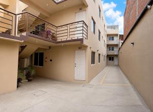 an empty courtyard of an apartment building with a white door at Casa Postal, Loft cerca del Centro, wifi rápido y estacionamiento in Oaxaca City