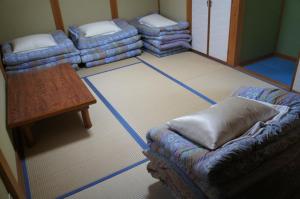 a living room with a couch and a table at GATE80香住 無人宿 完全セルフ 予約メッセージ欄確認要す スマートロック 暗証番号チェックイン 素泊まり専門 アメニティ持参で格安滞在 セコム24h監視 駐車場10台 in Kami