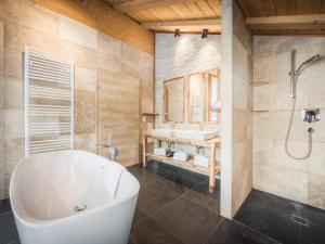 a bathroom with a white tub and a sink at Modern chalet in the willow roof in Leutasch