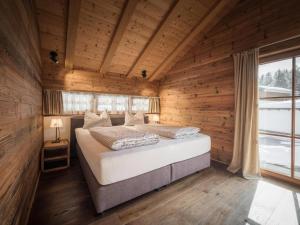 a bedroom with a bed in a wooden cabin at Modern chalet in the willow roof in Leutasch
