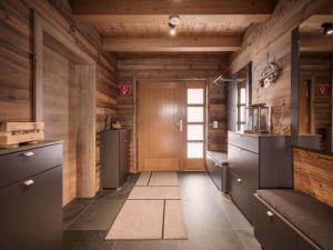 a kitchen with wooden walls and a door at Modern chalet in the willow roof in Leutasch +13 photos