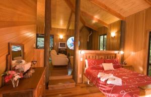 a bedroom with a bed in a wooden room at Springbrook Lyrebird Retreat in Springbrook
