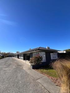 a black building on the side of a road at Aorangi Motel in Fairlie