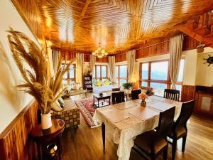 a living room with a wooden ceiling and a table at The Sayo Ratnari in Bāgi