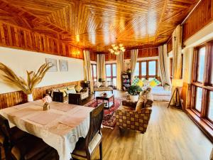 a living room with a wooden ceiling and a table at The Sayo Ratnari in Bāgi