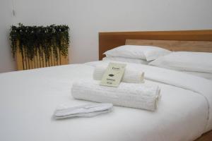a white bed with towels and a sign on it at Milan Luxury Loft with Sauna & Jacuzzi in Milan