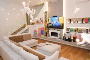 a living room with a white couch and a tv at Milan Luxury Loft with Sauna & Jacuzzi in Milan