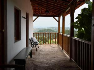 a porch of a house with a chair on a balcony at Casa da Sequeirinha in Barreiros
