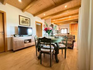 a dining room with a table and chairs and a television at Casa da Sequeirinha in Barreiros