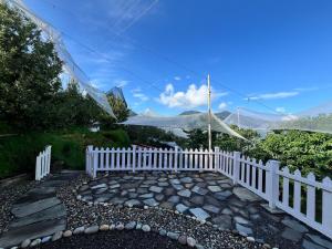 a white picket fence with mountains in the background at The Sayo Ratnari in Bāgi