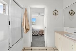 a white bathroom with a shower and a sink at Seascape U7 in Golden Beach