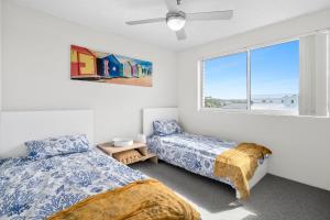 a bedroom with two beds and a window at Seascape U7 in Golden Beach