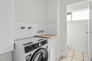 a white laundry room with a washer and dryer at Seascape U7 in Golden Beach +6 photos