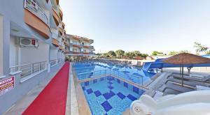 a pool at a hotel with chairs and an umbrella at Sare Hotel in Erdek