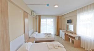 a hotel room with two beds and a mirror at Sare Hotel in Erdek